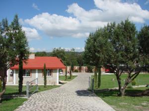 un camino de ladrillo que conduce a una casa con techo rojo en Los Ócalos Villas, en Huasca de Ocampo