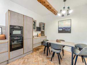 a kitchen with a table and chairs in a room at The Retreat in Sudbrooke