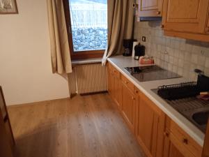 una cocina con fregadero y una ventana. en Apartement Noggler, en Malles Venosta