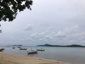 un groupe de bateaux dans l'eau sur une plage dans l'établissement Seaside vacation, à Rawai Beach