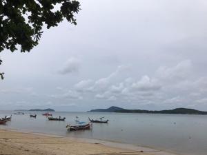 a group of boats in the water on a beach at Seaside vacation in Rawai Beach
