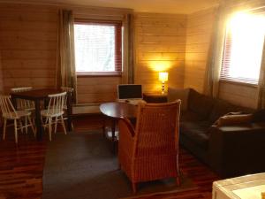 un soggiorno con divano e tavolo con computer di Kultala Cottage a Korkeakoski Altre 7 foto