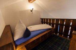 a wooden bed with pillows on it in a room at Vitusfort Appartement "Highlander Suite" in Füssen