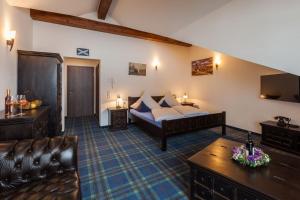 Vitusfort Doppelzimmer Edinburgh في فوسن: غرفه فندقيه بسرير واريكه