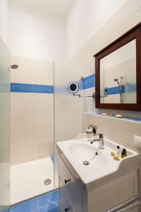 La salle de bains est pourvue d'un lavabo et d'une douche avec un miroir. dans l'établissement Vitusfort Doppelzimmer Edinburgh, à Füssen