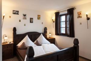 a bedroom with a wooden bed with white pillows at Vitusfort Appartement "Guinness Suite" in Füssen