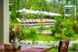 a table with a vase of flowers on it at Khmer House Resort in Siem Reap