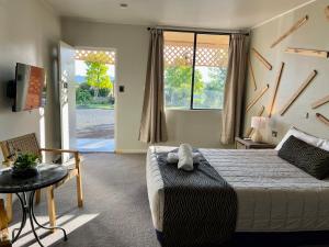 a bedroom with a bed and a chair and a window at Quirindi Sunflower Motor Inn in Quirindi