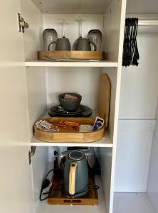 a kitchen pantry with a tea kettle on a shelf at Quirindi Sunflower Motor Inn in Quirindi