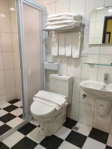 a white bathroom with a toilet and a sink at 童趣漫旅溜滑梯民宿 可預約包棟 in Taitung City