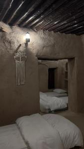 A bed or beds in a room at نزل حارة المسفاة Harit AL Misfah Inn