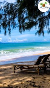 a picnic table sitting on the beach near the ocean at Lanta L.D. Beach Bungalow in Ko Lanta