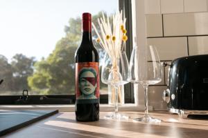 a bottle of wine sitting on a counter with two glasses at Wild Life Cabin 1 - Grampians in Halls Gap