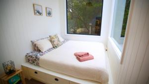 a small bedroom with a bed with a pink towel on it at Wild Life Cabin 1 - Grampians in Halls Gap