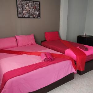 two beds in a room with pink sheets at Haadrin village Fullmoon in Haad Rin