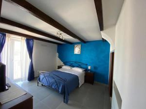 ein blaues Schlafzimmer mit einem Bett und einer blauen Wand in der Unterkunft Nicola’s house in Procida