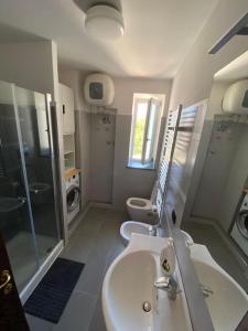 ein Bad mit einem Waschbecken, einer Dusche und einem WC in der Unterkunft Nicola’s house in Procida