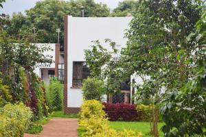 une maison avec un jardin en face dans l'établissement THE PLANTAINS PLACE, à Karatina