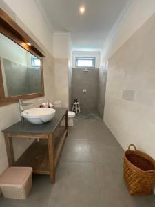 a bathroom with a sink and a toilet at Kubuwatu Boutique Accommodation in Gili Trawangan