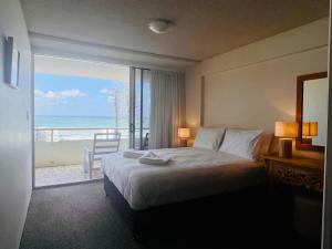 a bedroom with a bed and a view of the ocean at Park Towers Holiday Units in Gold Coast