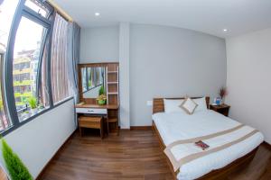 a bedroom with a bed and a large window at Ngọc Mai Hotel in Da Lat