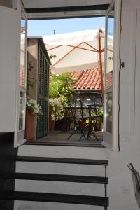 an open porch with a table and an umbrella at La Terrazza di Vico Olivi B&B in Ventimiglia