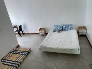 ein Schlafzimmer mit einem Bett mit zwei Nachttischen und zwei Tischen in der Unterkunft Mansion house in Antipolo