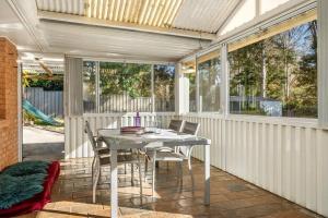 Un comedor con una mesa y sillas blancas. en Kurrajong Village Delight, en Kurrajong