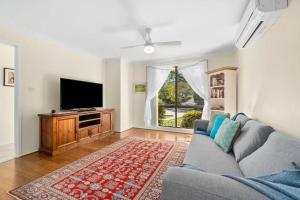 Una sala de estar con un sofá y un televisor de pantalla plana. en Kurrajong Village Delight, en Kurrajong