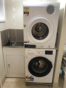 a washing machine and a sink in a kitchen at Branxton Baybrook Apartment in Branxton