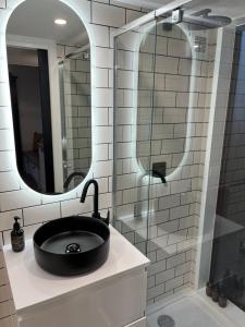 baño con lavabo negro y espejo en Wild Life Cabin 1 - Grampians, en Halls Gap