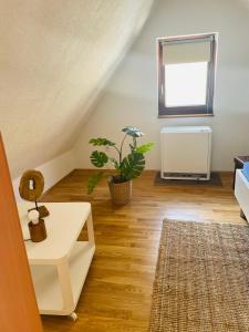 una sala de estar con una mesa blanca y una planta en Maisonette Wohnung Sophie mit Balkon und Terrasse, en Weikersheim