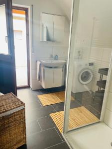 y baño con lavabo y lavadora. en Maisonette Wohnung Sophie mit Balkon und Terrasse en Weikersheim