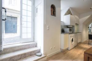 a kitchen with a window and a washing machine at BmyGuest - Castelo Charming Flat in Lisbon +11 photos