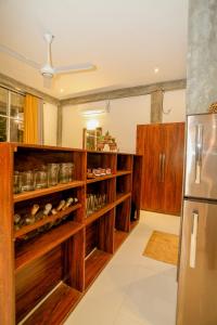 a kitchen with wooden cabinets and a refrigerator at Villa Sanni 18 in Hikkaduwa