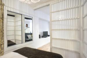 リスボンにあるBmyGuest - Castelo Charming Flatの白い壁のベッドルーム(大きな鏡付)