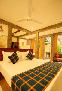 a bedroom with a large bed with a ceiling fan at Villa Sanni 18 in Hikkaduwa