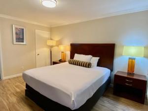 une chambre d'hôtel avec un grand lit et deux lampes dans l'établissement Rose Garden Inn, à Santa Barbara