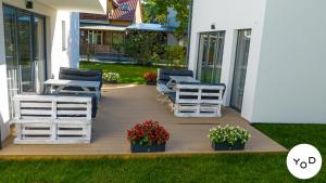 a deck with chairs and flowers on a house at Yod Pustkowo in Pustkowo