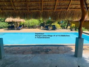 - un panneau indiquant la piscine d'un complexe dans l'établissement Shangri-Lanka Village, à Tissamaharama