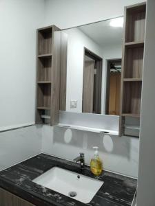 a bathroom with a sink and a mirror at Lovely Sweet Home in Johor Bahru