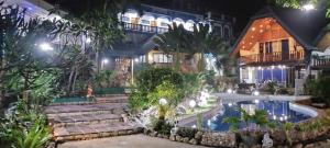 a house with a swimming pool at night at Princess of Coron Austrian Resort in Coron