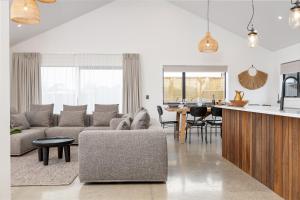 a living room with a couch and a table at The Green House - Luxury Eco Escape in Martinborough 
