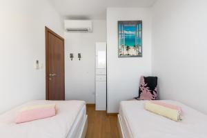 two beds in a room with white walls at Marina Lux Split in Split
