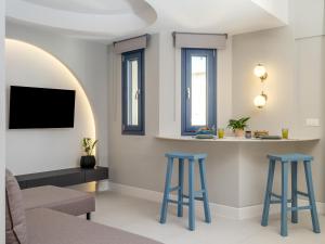 een woonkamer met twee blauwe krukken en een tv bij Evans Luxurious Apartment 4 in Heraklion