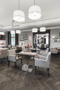ein Esszimmer mit Stühlen, Tischen und Spiegeln in der Unterkunft Red Baron Hotel & Restaurant in Świdnica