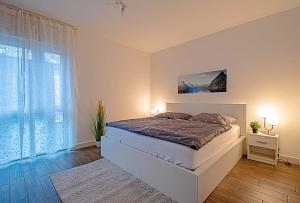 ein Schlafzimmer mit einem Bett und einem großen Fenster in der Unterkunft 150qm Haus mit 4 Schlafzimmern, Sauna, Parkplatz in Lüneburg