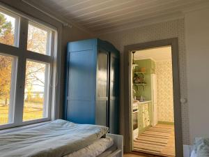 Charmig stuga på bondgård في Norrfjärden: غرفة بها ثلاجة زرقاء ومطبخ