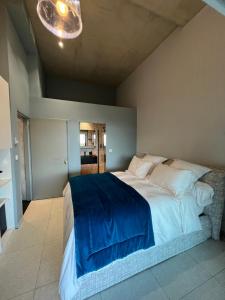 ein Schlafzimmer mit einem großen Bett mit einer blauen Decke in der Unterkunft Suite 28 in Treilles