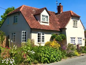 a white house with a red roof at Corner House Luxury BnB in Little Dunmow